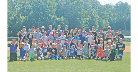 Baseball campers huddle for a photo before taking to the outfield to close out the summer fun.