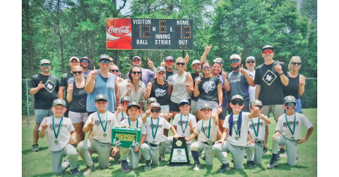 The Lumpkin County 8U team, backed by their coaches and parents, celebrate the State Championship victory.
