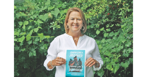 Dahlonega resident Lisa Raber proudly displays the cover of an upcoming self-help book she co-authored.