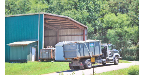 A truck hauls a load of garbage towards the Lumpkin County Transfer Station’s main building.