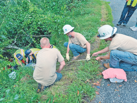 Neighbors and passersby joined together to help rescue Lamar Laird from the bottom of a steep embankment after the local resident was pinned beneath his riding mower last Tuesday.