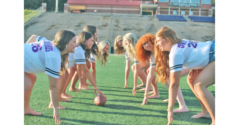 The Lumpkin senior cheerleaders spend a lighthearted moment channeling their inner football players as the offensive and defensive lines would line up during a game on Friday Night.