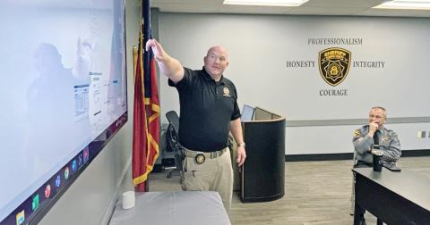 Sheriff Stacy Jarrard (right) looks on as Investigator Hasley Gipson reviews the evidence which led to an out-of-state suspect who is believed to be responsible for scamming Lumpkin County out of nearly $400,000.