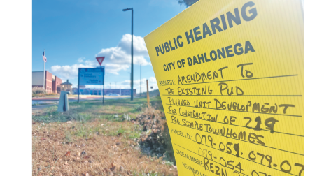 A sign just before the roundabout in front of the new Aquatic Center on Pinetree Way advertises two December public hearings.