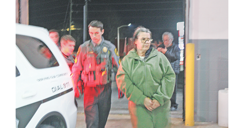 Magdalena Magadan is escorted by Deputy Zachary Bogue into the Lumpkin County Detention Center where the Florida resident was charged with theft by deception.