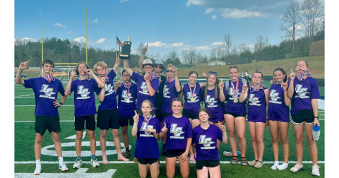 The middle school track team shows off their newly-earned hardware at the Region Championships.