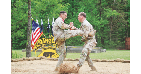 Staff Sergeant Hunter Green (right) catches a kick from Staff Sergeant Ben Ronemus during a hand-to-hand combat demonstration at Camp Frank D. Merrill’s 5th Battalion Army Rangers Open House.