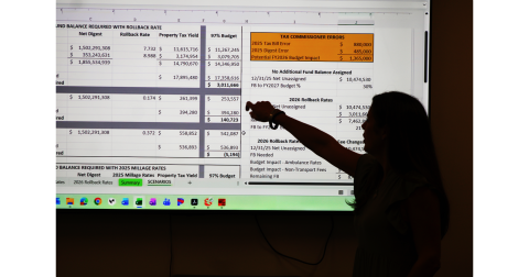 Lumpkin County Finance Director Abby Branan points at a slide in her 2027 budget presentation. The financial impact of errors in the 2025 property tax calculation can be seen at the upper right.