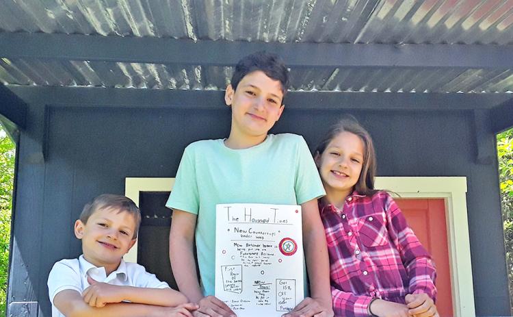 Junior journalists pictured (from left) Benjamin, Samuel, and Abigail Fuerstenberg show off the latest edition of The Household Times, the siblings' own homemade newspaper, made each week for their parents.