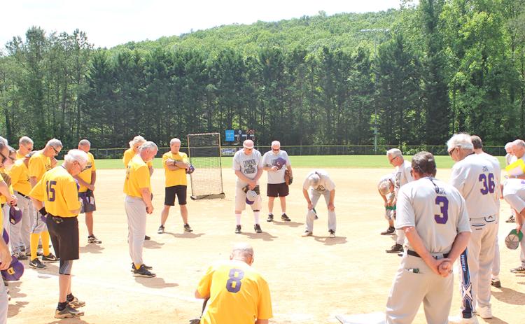 Members of Lumpkin County’s two senior softball teams, the LC Miners and the Dahlonega Gold, take a moment for prayer before playing their first game since last season after the coronavirus pandemic delayed the start of their season. All players were thankful to be back on the diamond after the long hiatus.