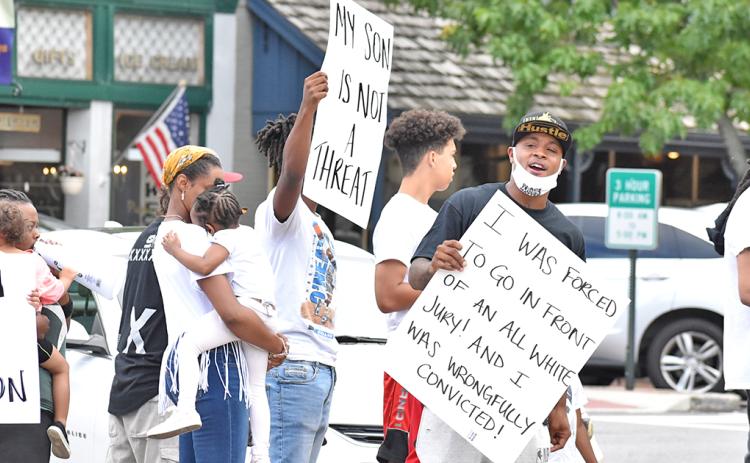 Local resident Antonio Head (far right) leads a rally along with family and friends on the Public Square.
