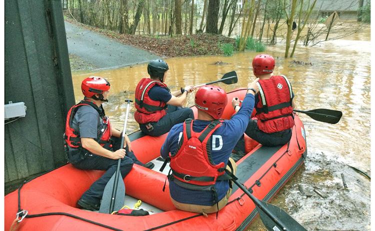 The Lumpkin County Swiftwater Rescue Team, including, from left, Chris Maloney, Derrick Haney, Eric Wimpy and Brennan Powell prepare to launch into the flood swollen waters at Golden Avenue. (Photo courtesy of David Wimpy)