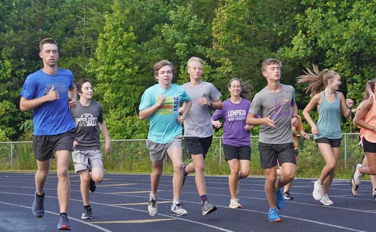 New LCHS Cross Country Head Coach Logan Turner, left, runs alongside his team during a recent summer workout. Turner says he's excited about the new role and the ability to have positive impact on kids' lives.