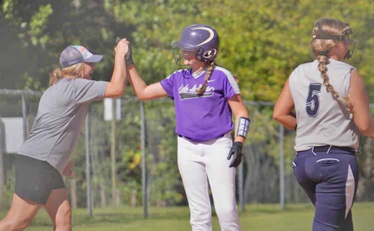 Head coach Brooke Grindle celebrates with Riley Dyer after she knocked in two runs with a double before advancing to third to give the Indians a 6-2 lead in the first inning.