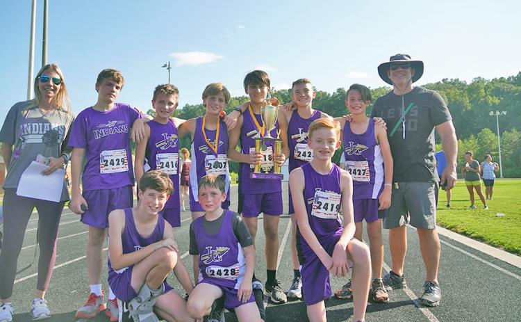 The LCMS boys cross country team celebrates with the trophy after claiming their second first-place finish of the season with five runners finishing in the top 15 of the event.