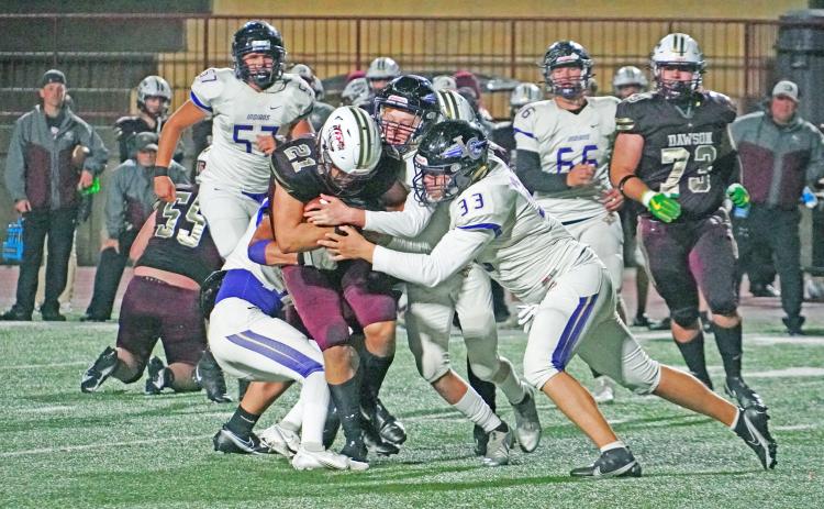 Andrew Adams (right) helps a group of Indians defenders take down the ball carrier to limit the damage in Friday night’s game against Dawson County. The Tigers outpaced en route to a 42-8 win over Lumpkin, giving up three touchdowns to the Tigers running back.