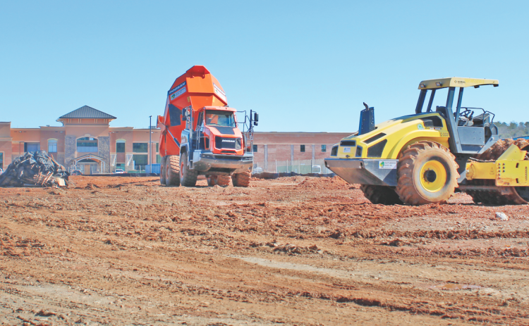 Construction vehicles mobilize in front of Cottrell Elementary, near the future site of the new recreation center.