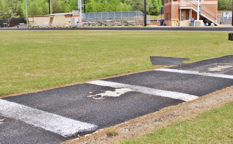 The pole vault approach, situated in the middle of the LCHS track, currently has several large divots that coaches have to cover with rubber scraps for athletes' safety.