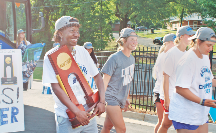 Reacting to the crowd of fans who had gathered in Dahlonega, UNG outfielder Mariah Wicker proudly holds the NCAA Division II Softball National Championship trophy as the Nighthawks return home. Once the bus arrived from Chattanooga, the team was enthusiastically greeted at their home stadium a few hours after winning the title. (photo by Keith Murden / The Nugget)