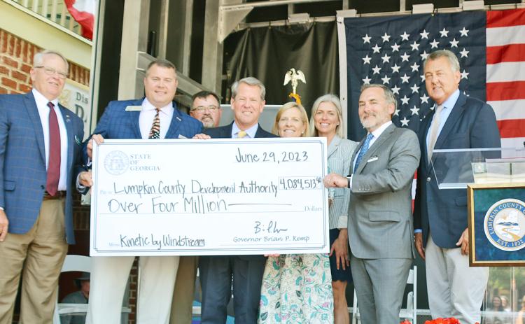 Officials hold up a check representing over four million dollars in state grant funding for broadband internet expansion in Lumpkin County. Pictured (from left) are Development Authority Board Chairman Henry Davis, Representative Will Wade, Board of Commissioners Chairman Chris Dockery, Governor Brian Kemp, First Lady Marty Kemp, Development Authority Director Rebecca Mincey, Windstream CEO Tony Thomas and Senator Steve Gooch.