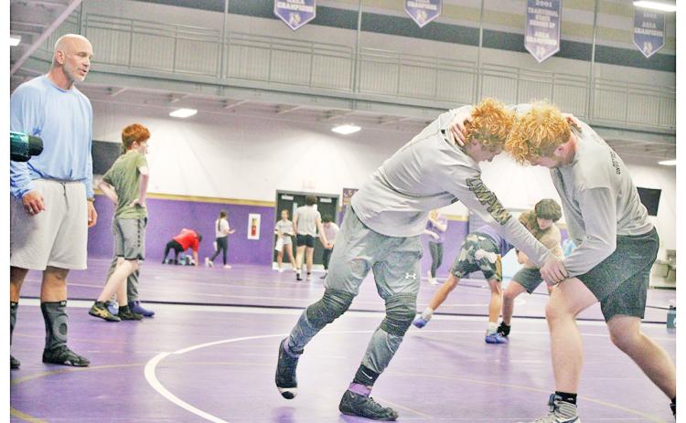 Coach Sean Hage watches wrestlers Austin Marshall and Jacob Pricer to make sure they get the most of their training ahead of the upcoming season.