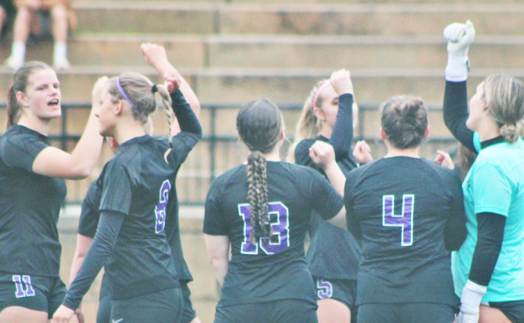 The lady Indians soccer team huddles together before storming the field.