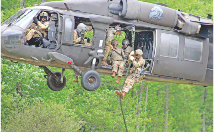 A fire team of Rangers from the U.S. Army’s 5th Ranger Training Battalion demonstrate a “fast rope” insertion from a UH-60 Black Hawk helicopter at Camp Frank D. Merrill on Saturday.