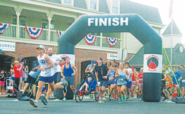 Competitors race out onto the course during the annual Fourth of July Firecracker 5K event.