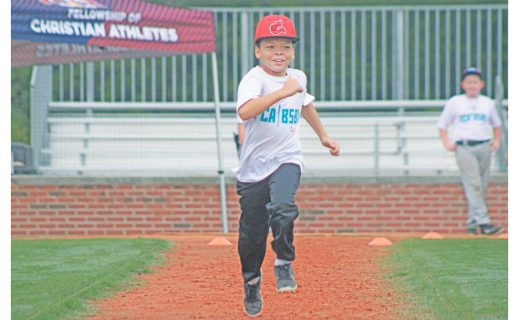 Blake Huff sprints to first during the FCA baseball summer camp at Lumpkin County High School.