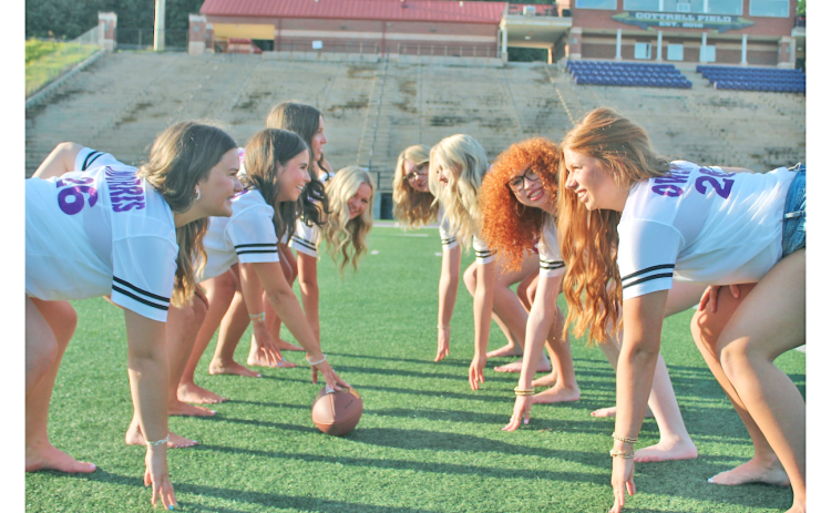The Lumpkin senior cheerleaders spend a lighthearted moment channeling their inner football players as the offensive and defensive lines would line up during a game on Friday Night.
