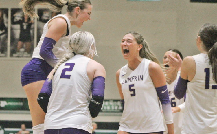 Layla Melius, Averie Simmons and Maddie Lee celebrate a Lumpkin score together.