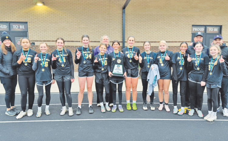 The 14U flag football team shows off their new State Championship trophy.