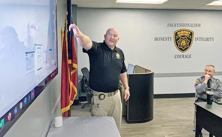 Sheriff Stacy Jarrard (right) looks on as Investigator Hasley Gipson reviews the evidence which led to an out-of-state suspect who is believed to be responsible for scamming Lumpkin County out of nearly $400,000.