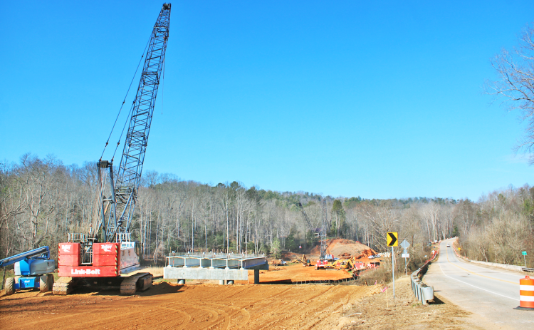 Heavy construction equipment can be seen next to the Chestatee River bridge on Highway 52 East. A section of GDOT’s replacement bridge has already been installed over the river.