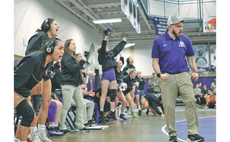 Coach Scott Degraff and the Lumpkin County Girls wrestling team celebrate a pin during one of their duals.