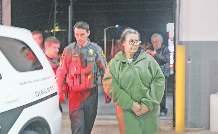 Magdalena Magadan is escorted by Deputy Zachary Bogue into the Lumpkin County Detention Center where the Florida resident was charged with theft by deception.