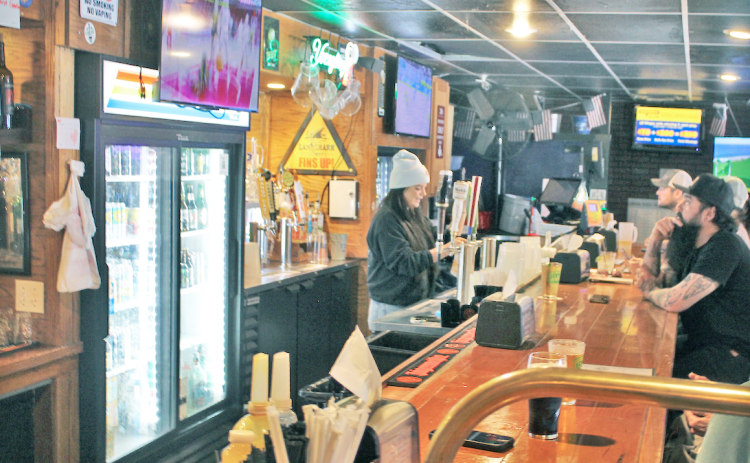 Bartender Victoria Woodall chats with customers as she pours a beer at Johnny B’s on Monday afternoon. The popular local restaurant and watering hole is set to close at the end of this month.