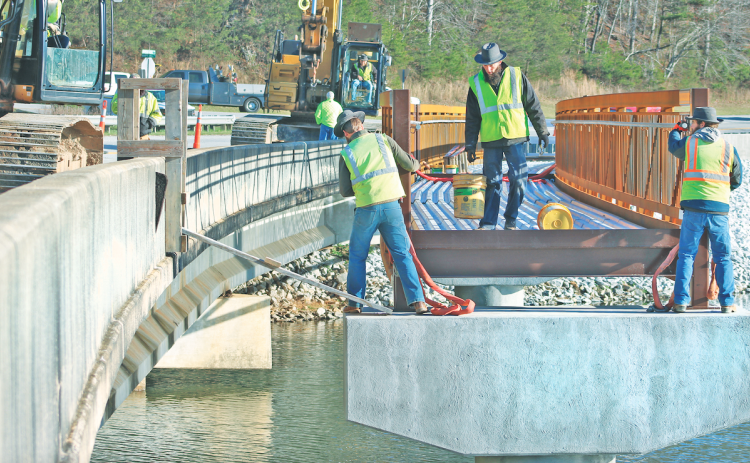 City contractors work to install segments of the much-anticipated pedestrian bridge at Lake Zwerner.