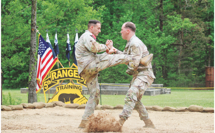 Staff Sergeant Hunter Green (right) catches a kick from Staff Sergeant Ben Ronemus during a hand-to-hand combat demonstration at Camp Frank D. Merrill’s 5th Battalion Army Rangers Open House.