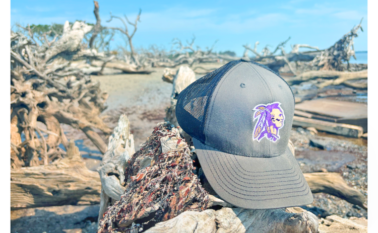 Sports writer Eligha Roper’s Lumpkin County sports cap takes a vacation at Driftwood Beach.