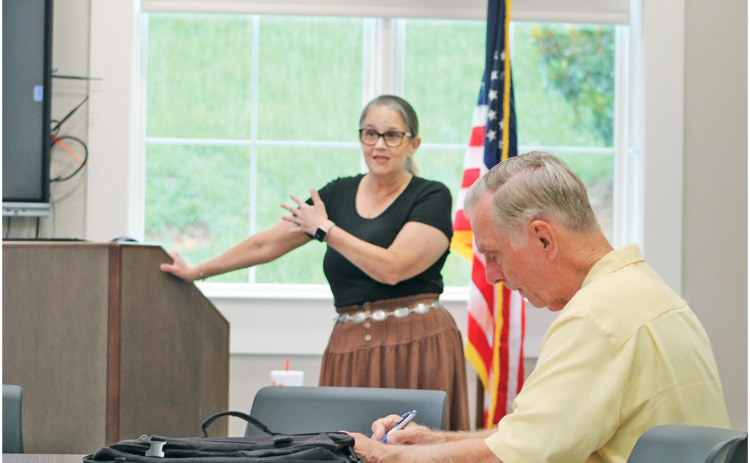 A local resident takes notes as Anita Anderson Spangler with Citizens for a Free Lumpkin speaks during a recent Homestead Property Tax Relief Seminar held in the library’s meeting room.