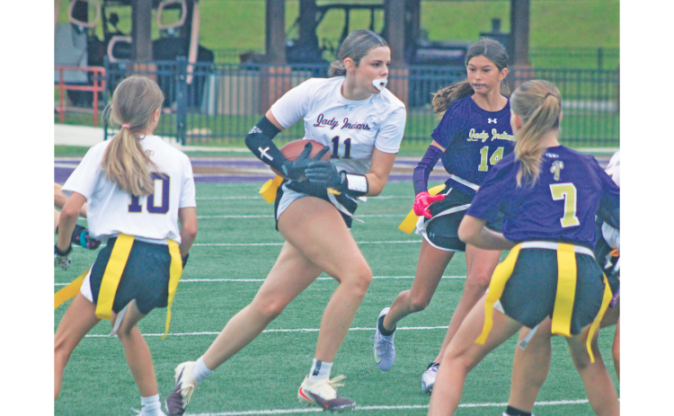 Lumpkin County’s Brooklyn Santiago looks for yardage as Team Purple defenders give chase.