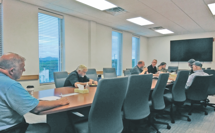 The Lumpkin County Airport Authority (right) considers changes to its hangar lease agreements and the construction of a new fuel farm as two audience members listen in from the opposite end of the table.
