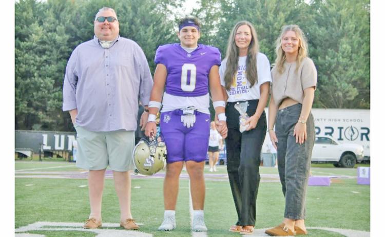 Weston Veater walks onto the field with his family during Senior Night.
