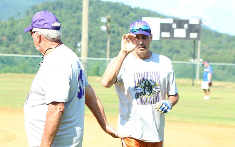 Jimmy “Four Quarters” Dollar gives “Hammering” Harvey Schmedlapp a high-five after Schmedlapp belted a solo home run over the centerfield fence during the Miners’ league doubleheader against the Lake Keowee Kings.