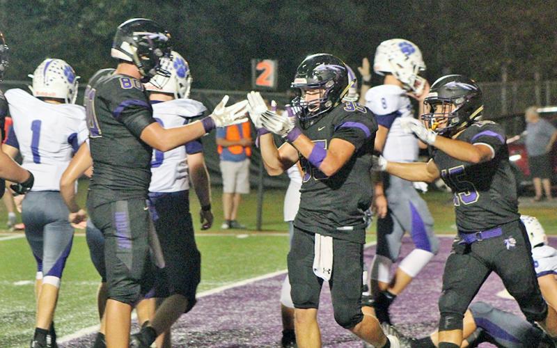 Indians running back BoJack Dowdy applauds his teammates after scoring his third touchdown in Lumpkin’s victory over the Gilmer County Bobcats last Friday. Dowdy rushed for 167 yards and three touchdowns in the game.