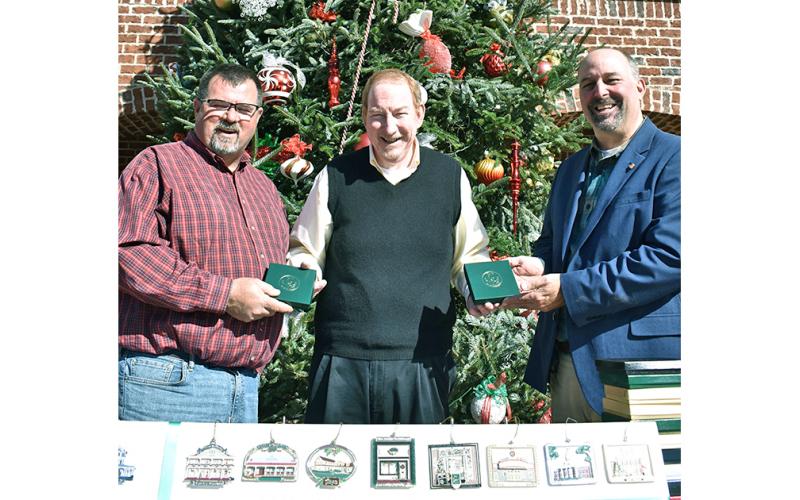 Local philanthropist and merchant Thomas Scanlin (center) spent a little time recently playing Santa to the community, gifting both Lumpkin County and the City of Dahlonega with complete sets of the Community Helping Place Official Dahlonega Christmas Ornament. Scanlin said he hopes the sets will be on permanent public display for all to enjoy. Accepting the gifts are (left) Lumpkin County BOC Chairman Chris Dockery and Dahlonega Mayor Sam Norton.
