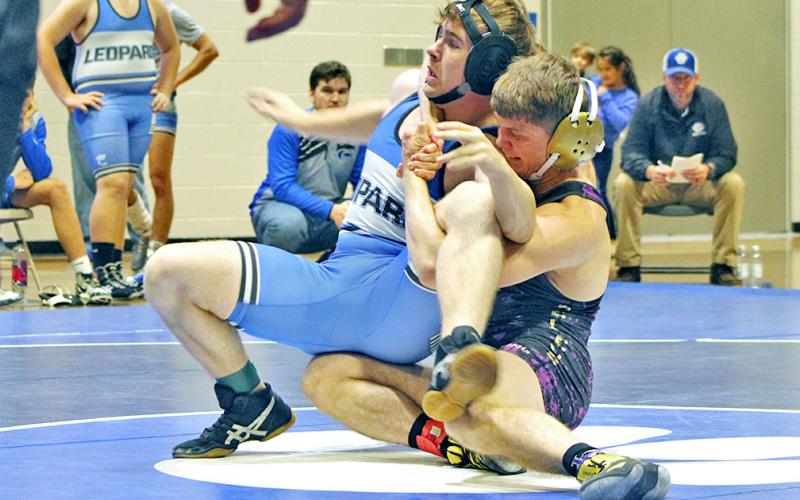 Lumpkin wrestler Levi Seabolt ties up his opponent before flipping him onto his back.