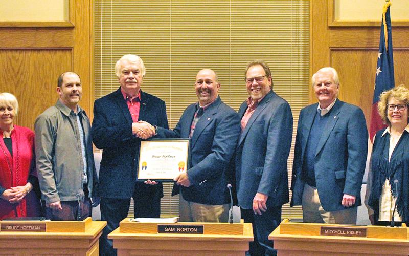 Members of the city council wish Bruce Hoffman (third from left) a fond farewell at his final city council meeting on Monday, Dec. 2. The council presented Hoffman with a plaque in recognition of his eight years of service on the local governmental body.
