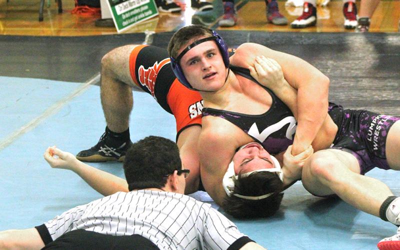 Lumpkin wrestler Ethan Kline squeezes the strength out of his opponent to get his shoulders to the mat for a win by pin during the Murray County Invitational this past weekend.